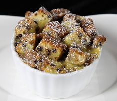 a white plate topped with a dessert covered in powdered sugar