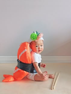 a baby sitting on the floor wearing a costume