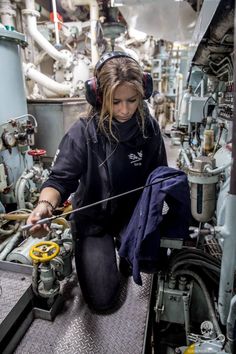 a woman in headphones working on machinery