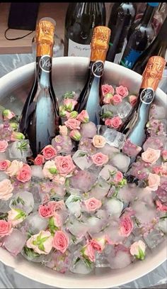 three bottles of champagne in ice with pink flowers