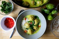 there are many different foods in bowls on the table, including rice and meatballs