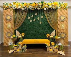 a decorated stage with yellow flowers and greenery on the wall, along with other decorations