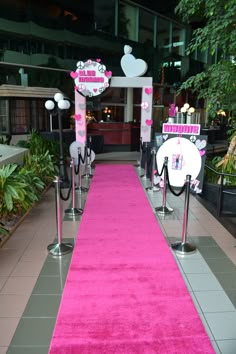 a pink carpeted walkway with white and black decorations on the end is decorated with hello kitty signs