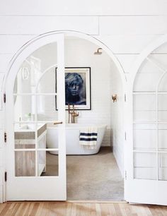 an image of a bathroom with white walls and wood flooring on the phone screen