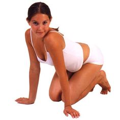 a woman kneeling on the ground in a white bathing suit