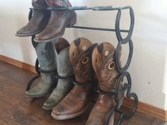 four pairs of cowboy boots hanging on a rack