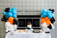 a table topped with balloons and cake in front of a basketball court sign that says party table backdrop