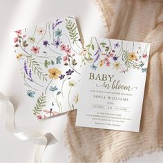 a baby in bloom card next to a white ribbon