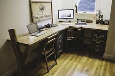 a desk with a laptop computer on top of it next to a wooden chair in front of a window