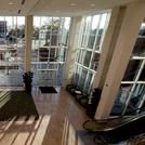 a living room filled with lots of windows next to a wooden floor covered in furniture