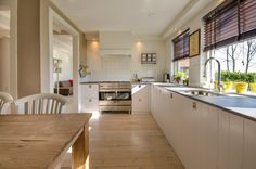 a kitchen with wooden floors and white cabinets