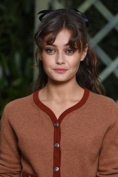 a woman with cat ears on her head wearing a brown cardigan and black tights