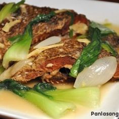 a white plate topped with meat and vegetables