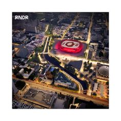 an aerial view of a stadium and surrounding city buildings at night with the lights on