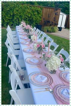 the table is set with pink and white plates, flowers and candles on them for a formal function