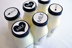 six milk bottles with labels on them sitting next to each other