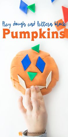 there is a pumpkin made out of colored blocks and being held by someone's hand