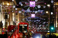 a busy city street filled with lots of traffic and christmas lights hanging from the ceiling