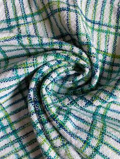 a green and white checkered fabric with blue, yellow, and green stripes on it