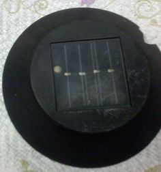 a small solar panel mounted to the side of a wall or ceiling fan on a bed