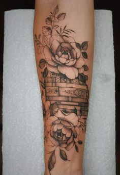 a woman's leg with a tattoo on it that has flowers and boxes in the middle