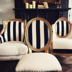 two black and white striped chairs sitting next to each other in front of a mirror