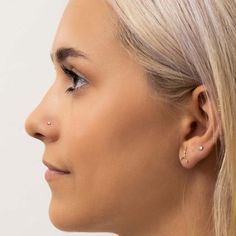 a woman with nose piercings looking off to the side