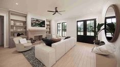 a large living room with white furniture and wood flooring, along with a ceiling fan