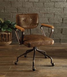 an office chair sitting on top of a hard wood floor next to a brick wall