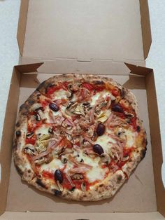 a pizza sitting inside of a box on top of a table