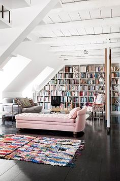 a room filled with lots of books and furniture