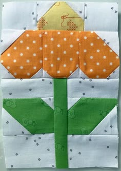 a close up of a patchwork flower on a piece of fabric with white dots