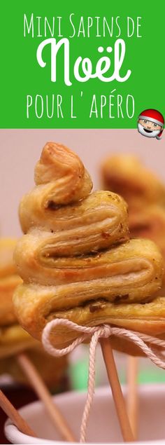 there are many small pastries on sticks in the white bowl with green lettering that says, minispins de noel pour l'apero