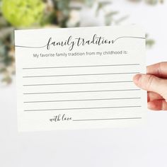 a person holding up a card with the words family tradition written on it in cursive writing