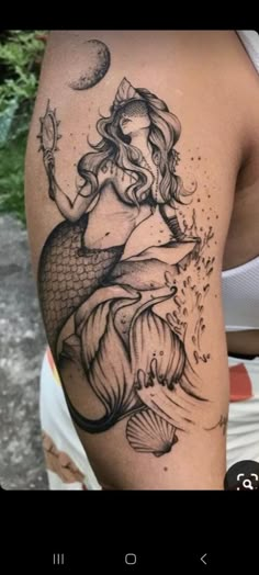 a woman with a mermaid tattoo on her arm