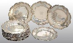 a group of silver plates sitting next to each other