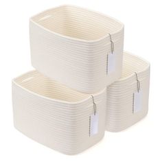 two white storage baskets with tags on them