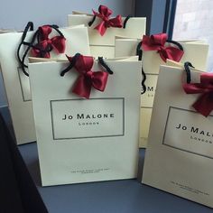 four bags with red bows are sitting on a table