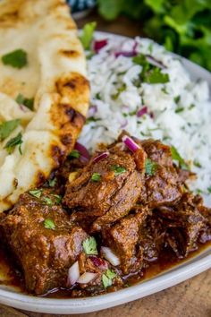 a plate with meat, rice and pita bread