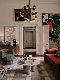 a living room filled with lots of furniture and art on the wall above it's doorway