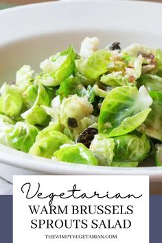 a white bowl filled with lettuce and raisins on top of a table