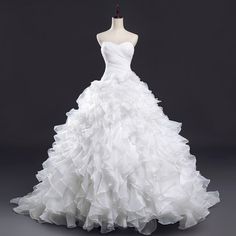 a white wedding dress on a mannequin with ruffles and beading