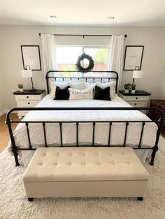 a bedroom with a bed, bench and window in the corner on carpeted flooring