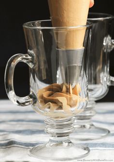 two clear cups filled with ice cream on top of a table