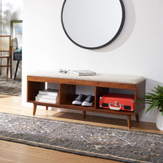 a room with a bench, mirror and potted plant on the floor in front of it