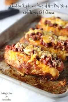 cheesy stuffed hot dog buns with turkey chili cheese on a baking sheet