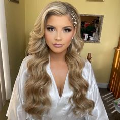 a woman with long blonde hair wearing a white robe and headpiece in a living room