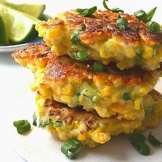 two crab cakes stacked on top of each other next to a bowl of lime wedges