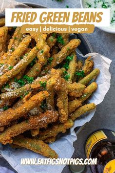 fried green beans in a bowl with parsley on top and ketchup next to it