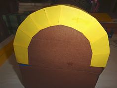 a paper hat made to look like a man's head with yellow hair and brown eyes